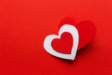 Valentines day. Paper hearts red and white on a red background. Holiday background