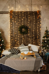 Christmas interior of a cozy bedroom with a Christmas tree and gifts
