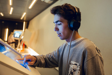 Guy interacting with touch screen in museum