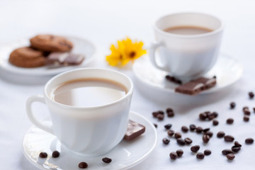 Two cup of coffee, oatmeal cookies and milk chocolate. Morning breakfast for two.