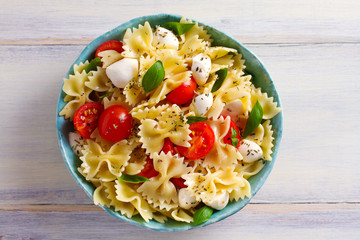 Caprese Pasta Salad. Pasta with mozzarella cheese, tomatoes and basil. View from above, top studio shot