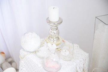 Romantic white decor with candlesticks and candles, beautiful details in a bright room. Wedding decor or Valentine's day