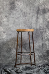 metal bar stool with a wooden seat on a gray background