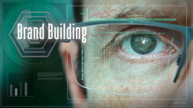 A close up of a businessman eye controlling a futuristic computer system with a Brand Building concept.