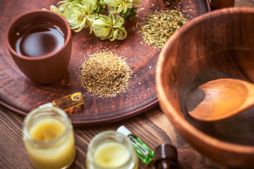 Preparing homemade mask with clay. A lot of ingredients for home made cosmetics in background