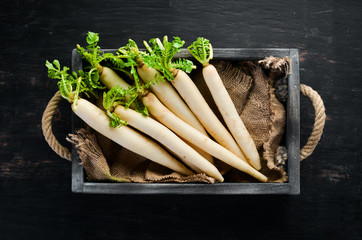 Radish Daikon in a wooden box. Radish. Vegetables. Top view. Free space for your text.