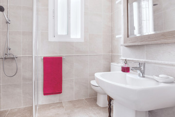 True real bathroom with toilet and sink with towels and purple soaps