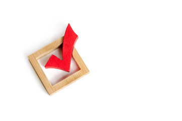 red wooden checkmark for voting on elections on a white background. Democracy and freedom....