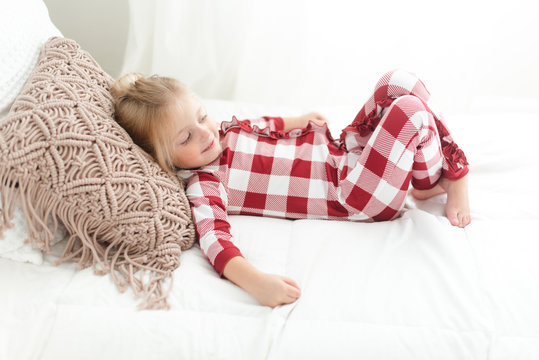 Young girl in pajamas lying on a bed