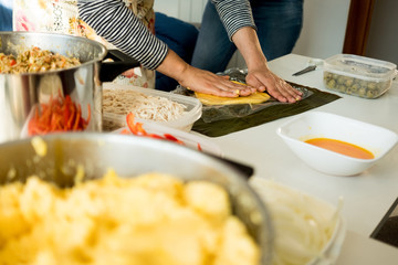 hands of young woman making venezuelan christmas dish hallacas with all ingredients on table - obrazy, fototapety, plakaty