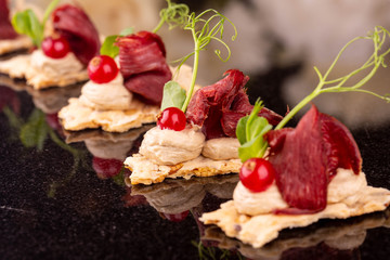Mousse with dried venison on small loaf with greens