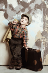 Boy wearing vintage closes holds suitcase, retro shot, 50s-60s