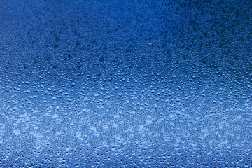 Macro abstract background design of window condensation in blue hues