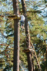Fototapeta premium Man passing cable route in etreme adventure rope park