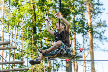 Boy passing cable route in extreme adventure rope park