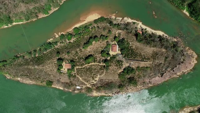 Drone image over island in the middle of the river Doce. Trees and small houses below. Landscape of Atlantic Forest Biome. Video recorded in southeastern Brazil.