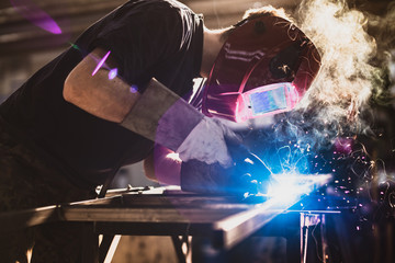 Fototapeta Worker is welding using mig mag welder constructions in the factory obraz