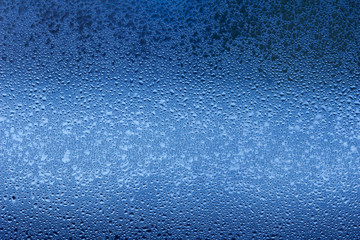 Macro abstract background design of window condensation in blue hues