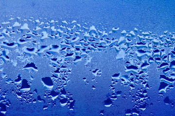 Macro abstract background design of window condensation in blue hues