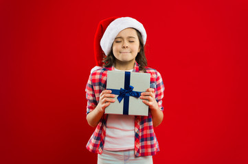 Present for Xmas. Childhood. Christmas shopping. New year party. Santa claus kid. Little girl child in santa red hat. Happy winter holidays. Small girl. Do it together. Holiday program