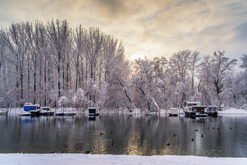 Frozen river with boats in the sunset