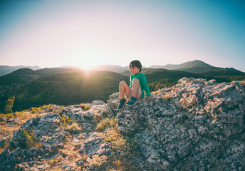 Naklejka premium A boy on top of a mountain.