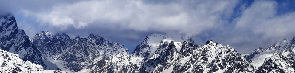 Fototapeta na wymiar Panorama of snowy mountains in haze at sunny winter day