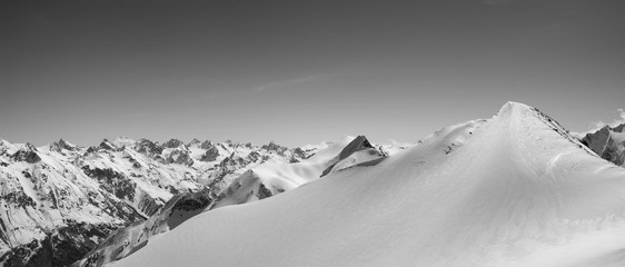 Black and white panorama of snowy mountains and ski slope for freeriding