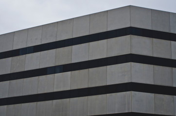 Fototapeta premium Looking at the building wall and the lines of the city windows in the downtown overcast city. 