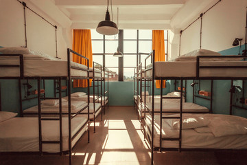 Interior of a house with many bunk beds. Light bedroom with clean sheets