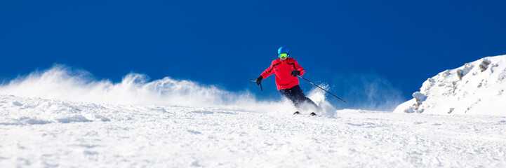 Man skiing on the prepared slope with fresh new powder snow
