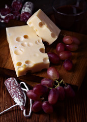 fuet spanish cheese and grape on wooden board