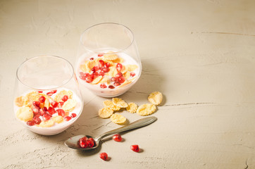 Fototapeta na wymiar Homemade yogurt with pomegranate and flakes/two glass homemade yogurt with pomegranate and flakes on a white table with copy space