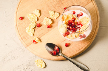 yogurt with garnet grains and flakes in glass/yogurt with garnet grains and flakes in glass on a wooden tray, top view