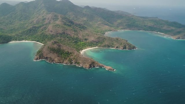 Aerial view of coast with tropical beach, island Limbones, lagoons and coral reefs. Neela cove, Philippines, Luzon. Coast ocean with turquoise water. Tropical landscape in Asia.