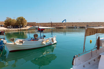 Fototapeta na wymiar raditional Greek fishing boats are moored in harbor of Rethimno town, Crete island, Greece
