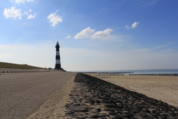 the lighthouse at the sea with the beach and sea in front