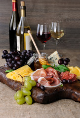 Antipasto catering platter with jerky bacon,  prosciutto, salami, cheese    and grapes on a wooden background
