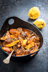 Traditional Iranian khoresh beh stew with chunks of lamb and quinces as top view in a modern style Japanese cast-iron roasting dish