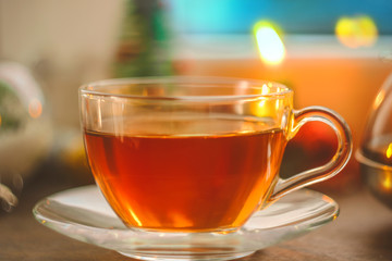 festive tea party. a cup of tea on the background of New Year and Christmas decorations. near the window with a blue, cold, winter background.