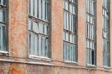 Fototapeta na wymiar The facade of an old abandoned factory with broken windows