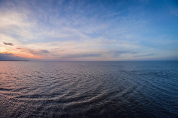Aerial panoramic view of sunset over ocean. Nothing but sky, clouds and water.