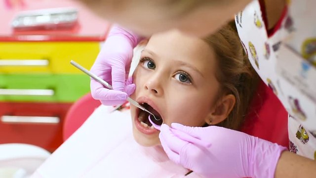 the child is a sweet girl without front milk teeth in the dental chair. Children's dentist