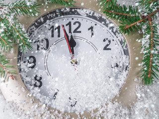 Clock on snow under decorated christmas tree - 239587633
