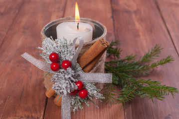 Candle in homemade candlesticks on a wooden background.