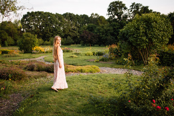 beautiful young girl in a white dress with long hair resting outdoors, amazing woman walking in the...