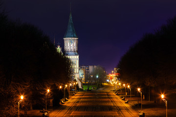 Fototapeta premium clock tower of the old gothic church illuminated by spotlights at night