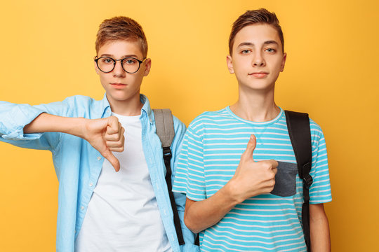 Two Teenagers, Guys Show Opposite Emotions, Friends Show Positive And Negative Gestures, On A Yellow Background