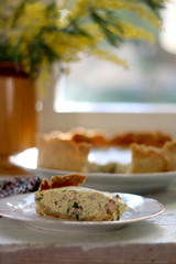 Slice of homemade quiche filled with cheese, ham and leek. Selective focus.