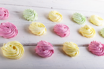 set of colored meringues on white wooden background. geometric pattern.